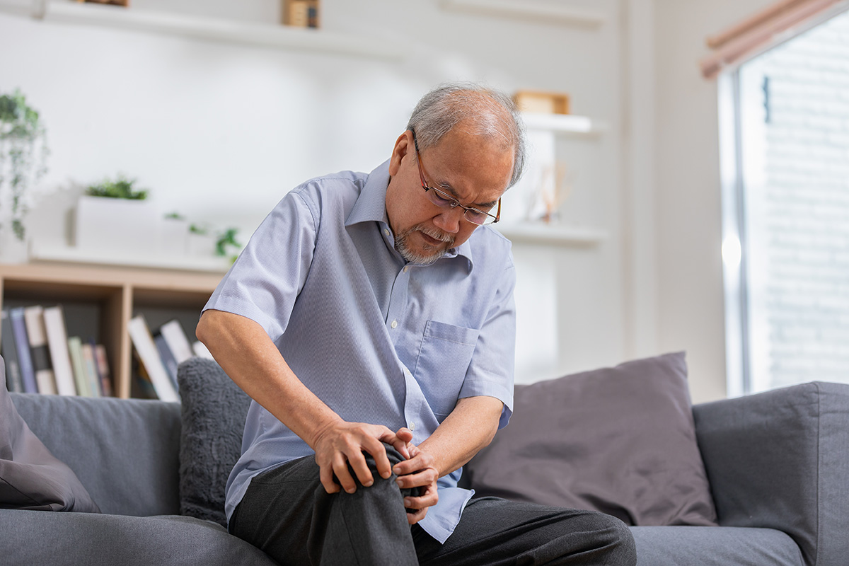 Man experiencing knee pain and stiffness associated with rheumatism.