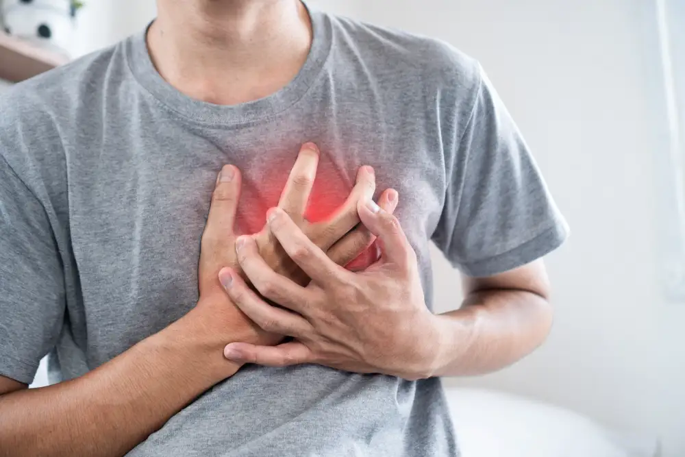 Man clutching his chest while experiencing discomfort.