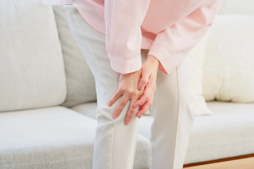 Woman experiencing knee pain and swelling due to psoriatic arthritis.