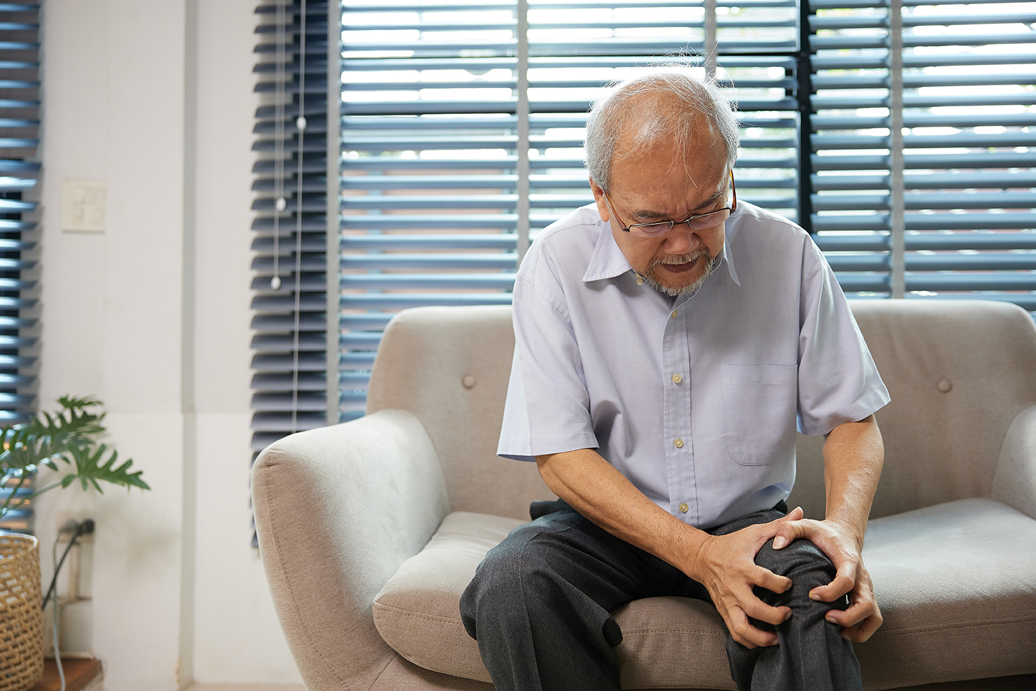 Person experiencing stiff joints and persistent aches related to rheumatism.