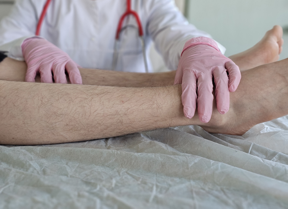 Rheumatologist examining a patient's ankle during a joint assessment